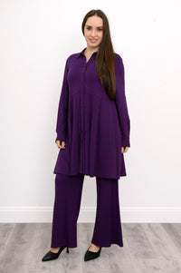 Wide studio shot of a relaxed-fit purple French terry tunic highlighting a strong vertical button placket.