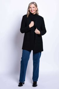 Woman showing black boiled wool coat partially open over jeans and a turtleneck