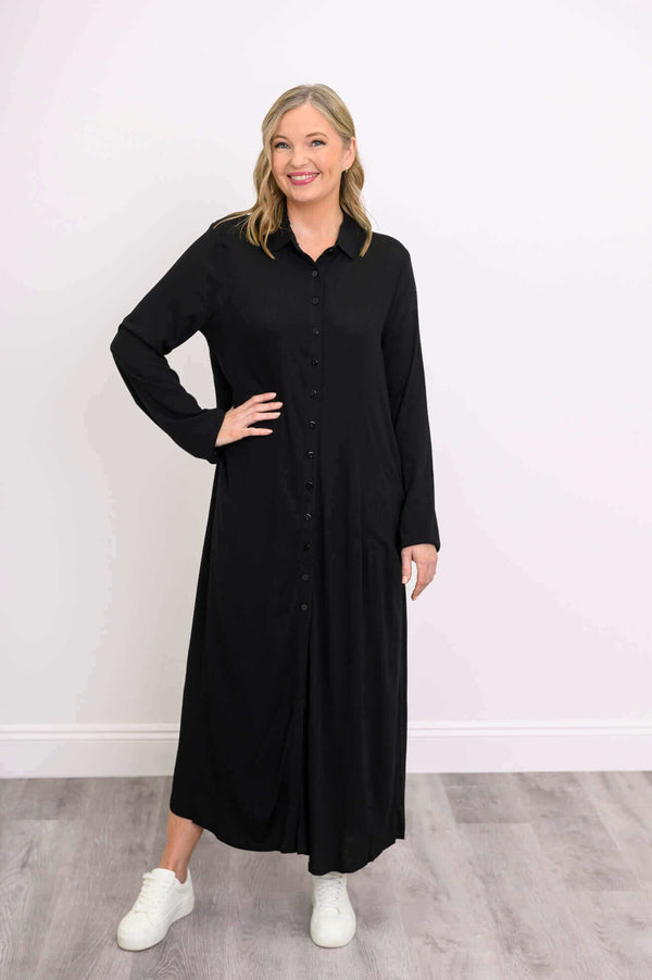 Woman wearing a black linen bamboo maxi shirt dress with long sleeves and button front