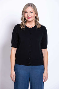 Woman wearing a black short-sleeve button-up cotton cardigan with blue pants