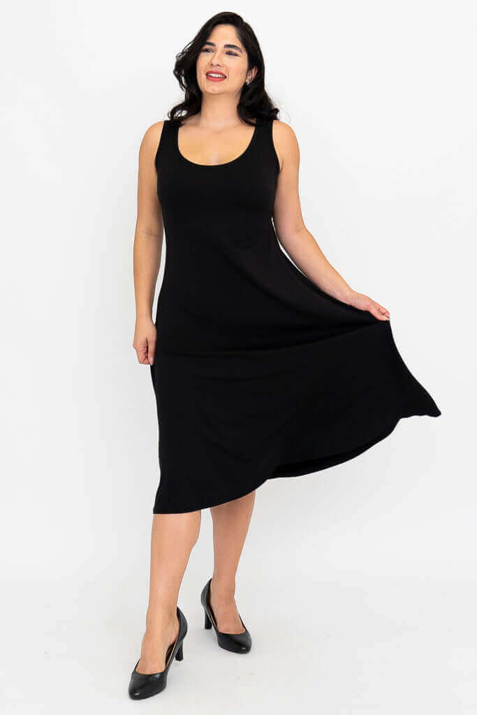 Woman in sleeveless black A-line dress pulling at skirt to show fabric movement