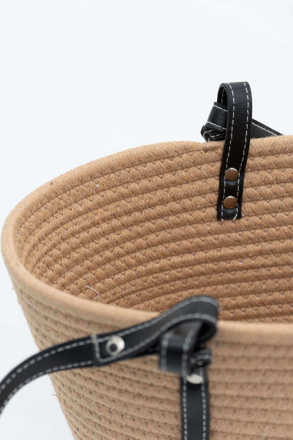 Black strap attachment with stitching on tan cotton tote bag