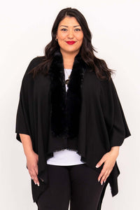 Woman modeling black wrap with faux fur collar over white top and black pants