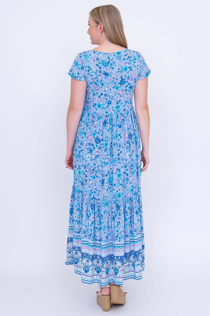 Woman in blue boho maxi dress, back view showing print and tiered skirt