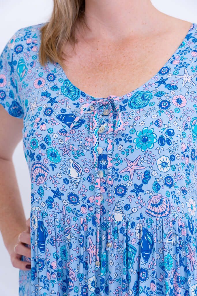 Close-up of neckline, buttons, and tie detail on blue boho maxi dress
