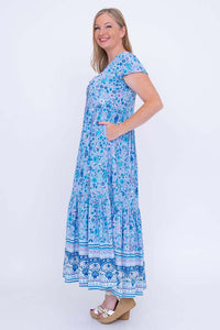 Woman in blue boho maxi dress, side view showing pockets and sleeves