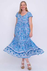 Woman swirling in blue boho maxi dress with tiered skirt, front view