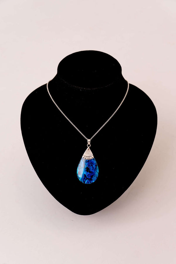 Sterling silver necklace with blue abalone pendant displayed on a black stand