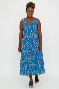 Woman wearing a blue maxi dress with colorful floral print, facing forward