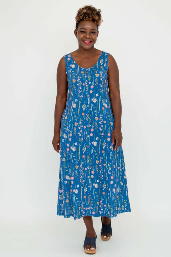 Woman wearing a blue maxi dress with colorful floral print, facing forward