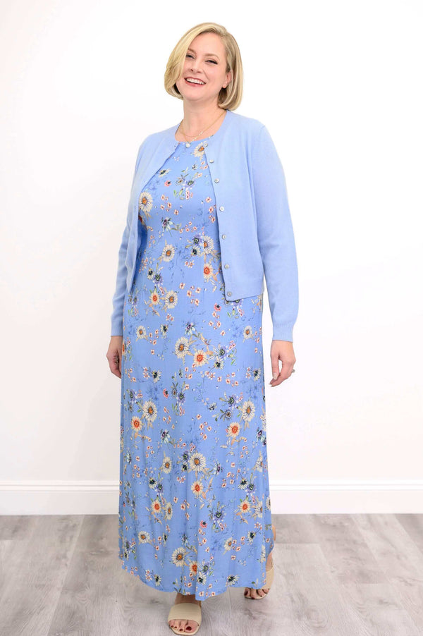 Woman wearing a blue floral shift maxi dress styled with a light blue cardigan