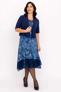 Woman in blue mesh-hem dress paired with a bolero, standing and smiling