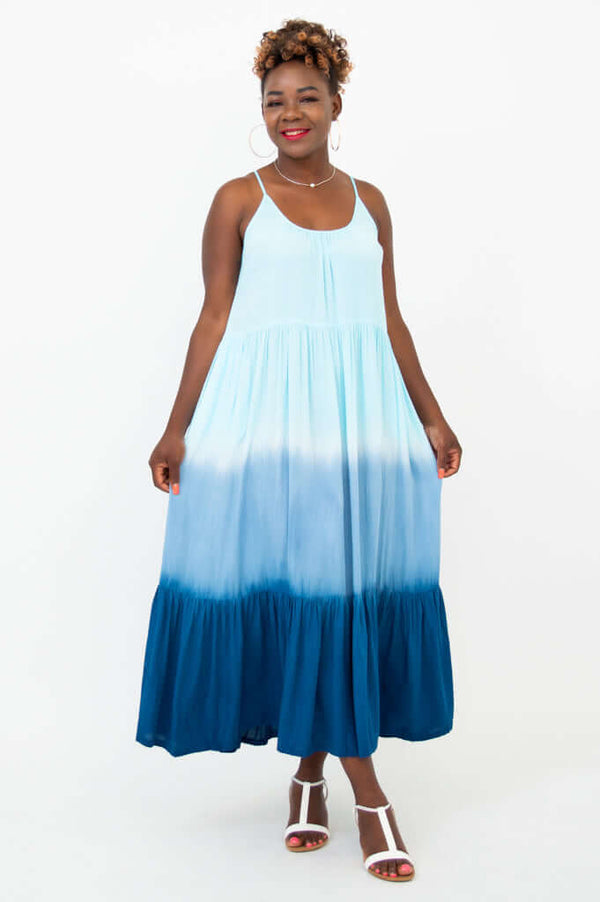 Front view of a woman in a light blue ombre maxi dress with adjustable spaghetti straps and pockets