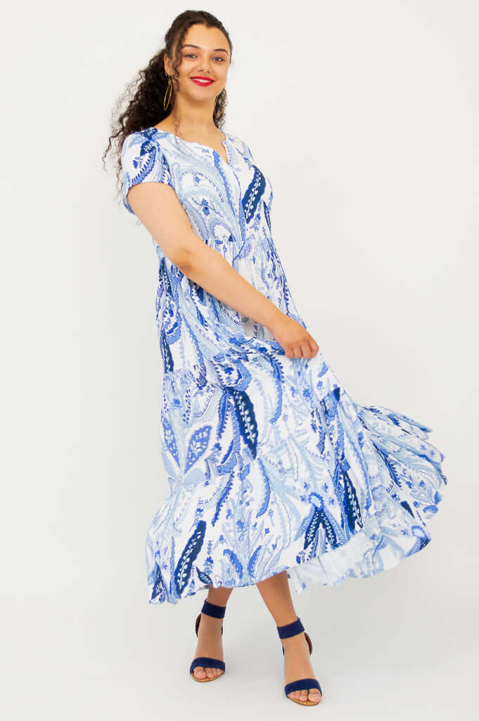 Woman twirling in a blue paisley maxi dress with short sleeves