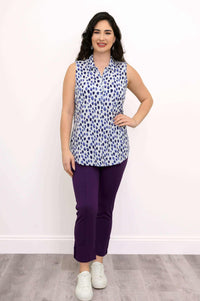 Front view of woman modeling sleeveless blue spotted zip tank and purple pants