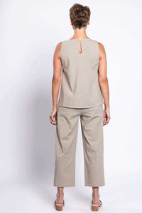 Back view of woman in light beige sleeveless top and cropped barrel-leg pants
