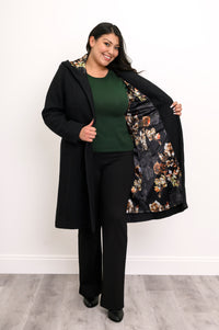 Woman showing off the black and multicolor floral satin lining of her long black coat