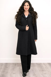Woman wearing a long black coat, black pant, and black shoes on a white background, front view