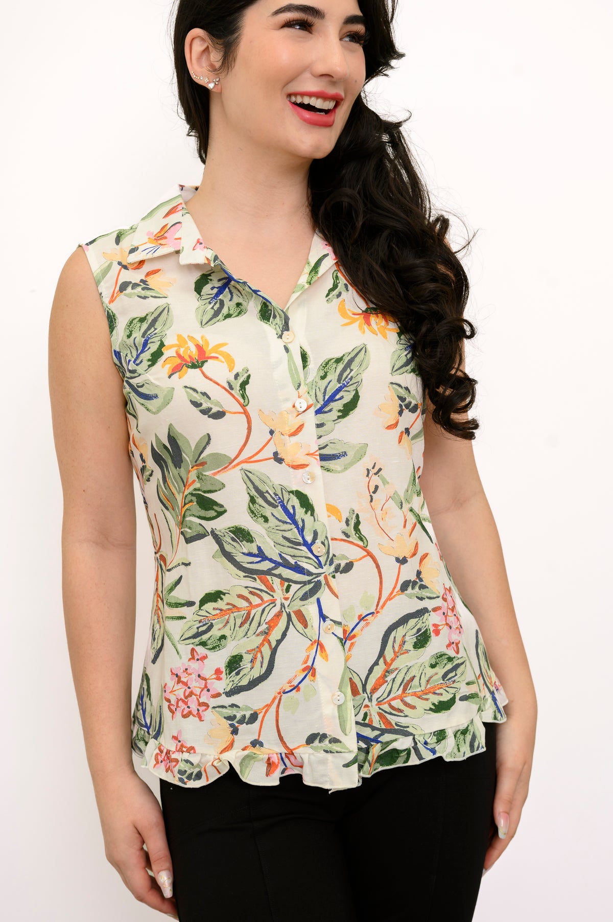 Front view woman wearing multicolor tropical print sleeveless top with green pants on a white background
