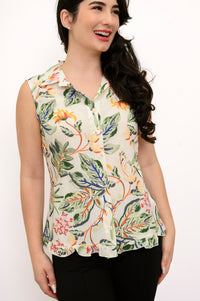 Front view woman wearing multicolor tropical print sleeveless top with green pants on a white background