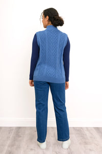 Back view of a blue cable knit vest, highlighting the vertical sweater texture and straight, ribbed hemline.