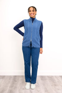 Front-facing view of a women's textured sleeveless sweater coat and blue jeans, showcasing a fluid silhouette.