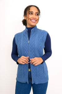 Front view of a women's cotton zip-up vest in a rich indigo shade, showing a comfortable layered look.