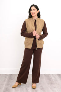 Angled view of a warm sandy-toned sleeveless sweater layer, showcasing a comfortable, body-skimming classic fit.