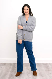 woman modelling a light grey shawl collar cardigan with front pockets