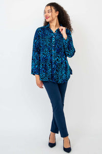 Model looking to the side in Cindy shirt and navy trousers, hand near collar