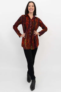 Woman posing in a vibrant, long sleeve smocked tunic top with hands on hips