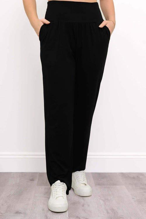 Front view of Clair black bamboo tapered pants with hands in pockets