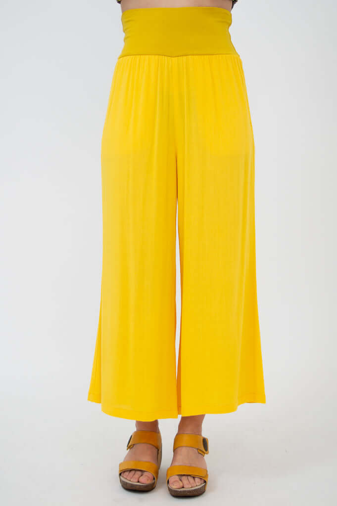 Front close-up of yellow capri pants with wide waistband and flare leg