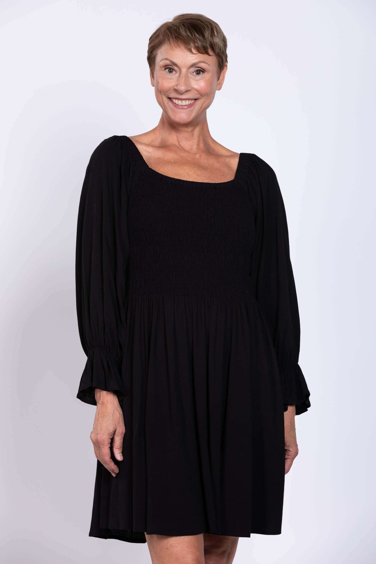 Close-up of model in black dress with square neckline and textured bodice