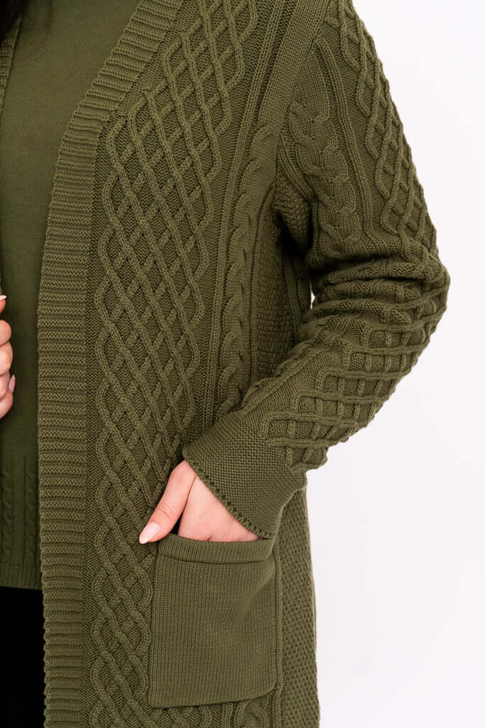Close-up of textured cable knit pattern and pocket on olive green cardigan