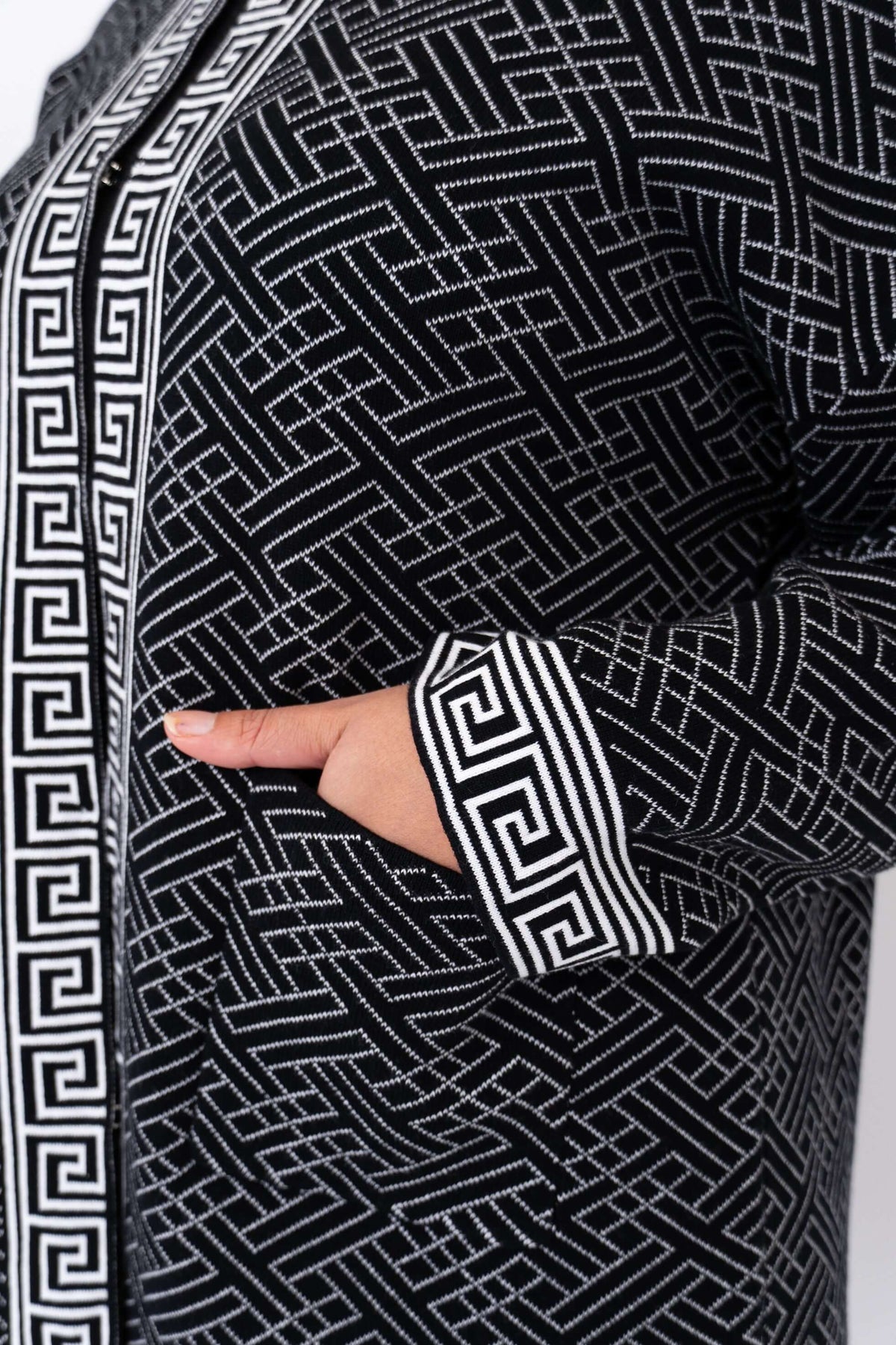 Detail of front pocket and bold geometric sleeve trim on black and white cardigan
