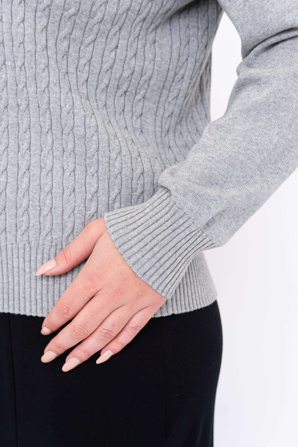 Close-up of ribbed cuff and cable texture on grey sweater