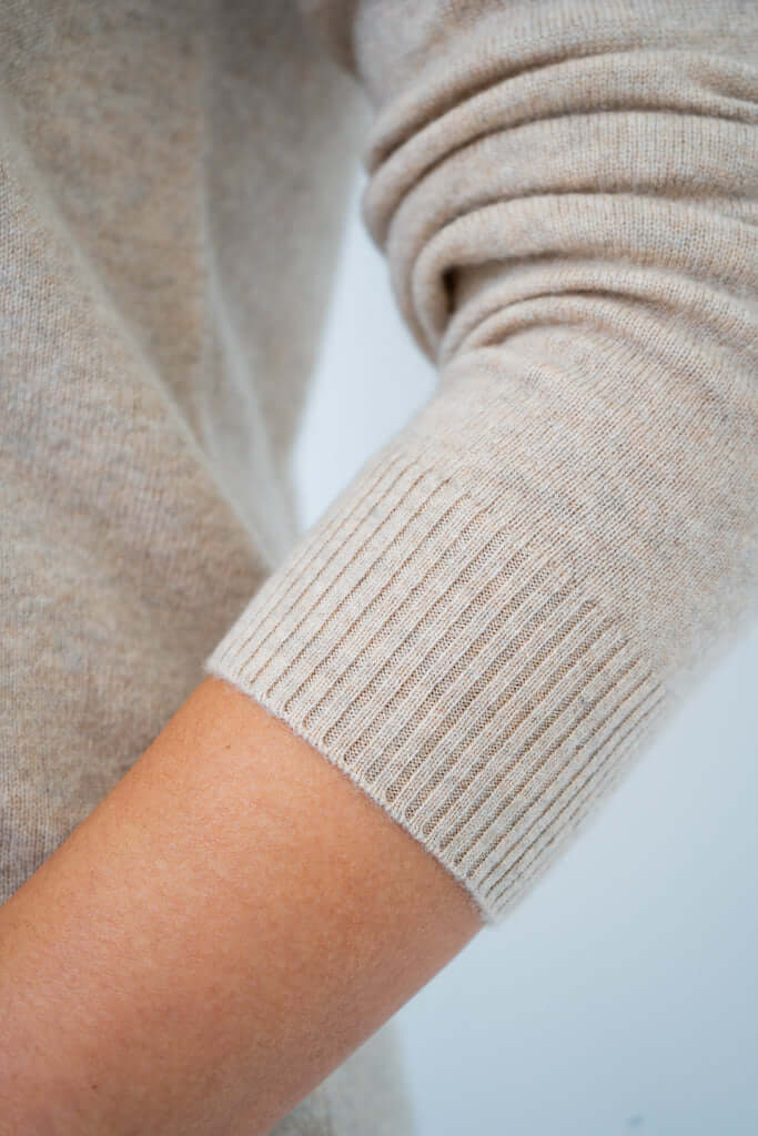 Close-up of ribbed cuff on beige cashmere wool sweater