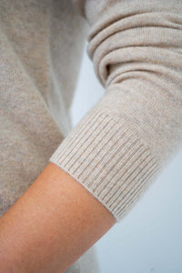 Close-up of ribbed cuff on beige cashmere wool sweater