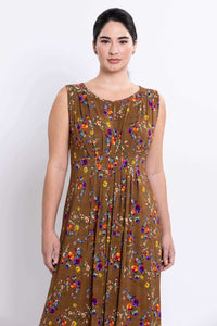 Close-up of sleeveless brown floral maxi dress showing pleat details