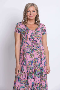 Close-up of upper torso in pink paisley dress showing neckline and button details