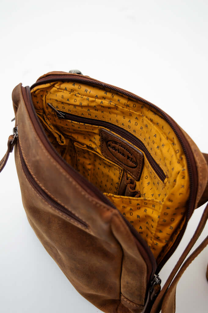 Detailed inside look of the brown leather bag with yellow branded fabric