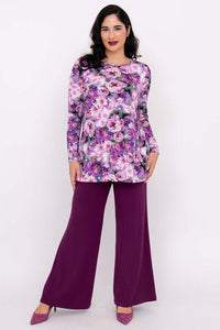 Model in colorful floral tunic top and wide-leg purple pants