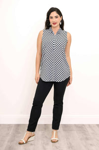 Woman standing confidently in black and white gingham tank top and black pants