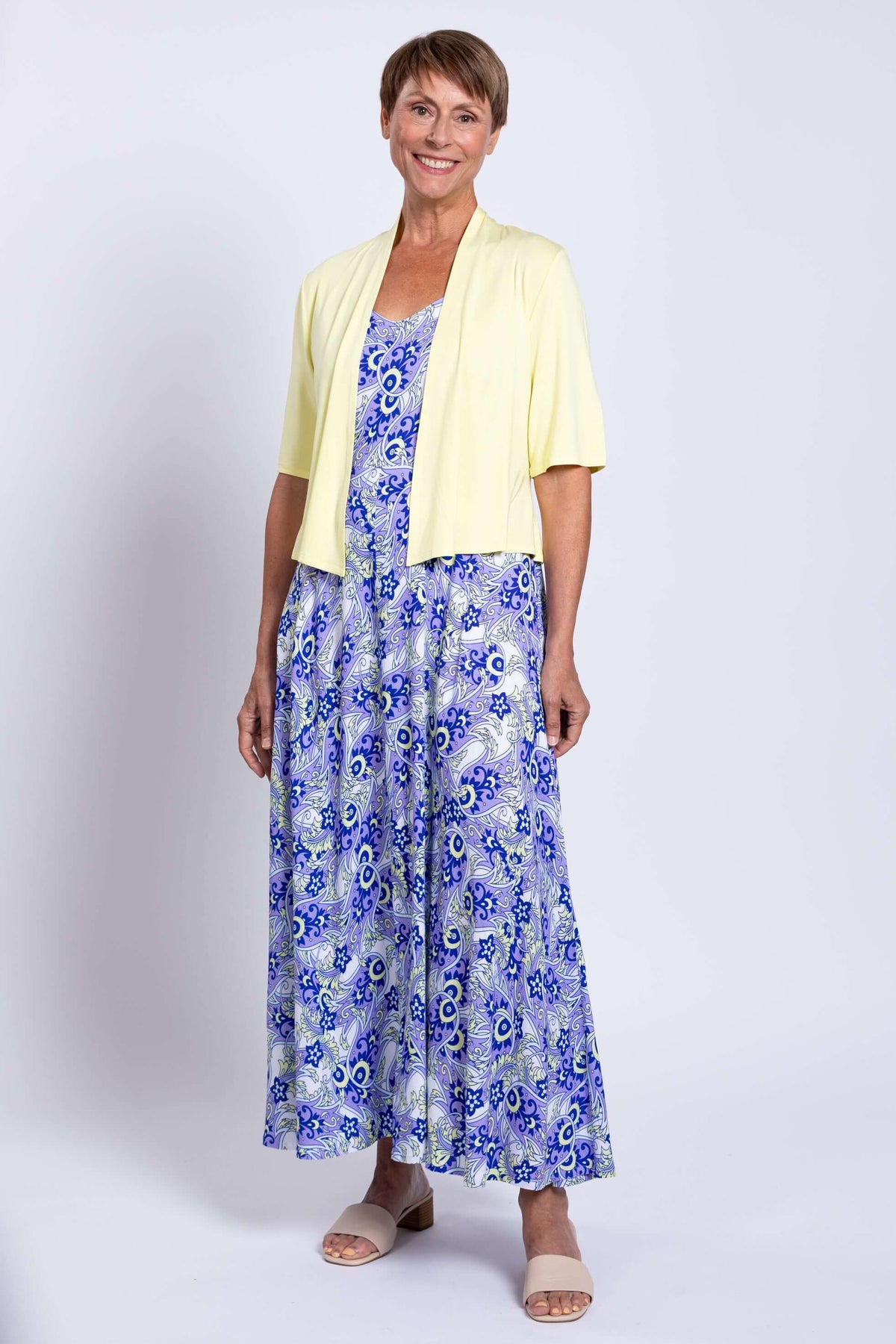 Woman wearing a yellow cardigan over a blue paisley maxi dress
