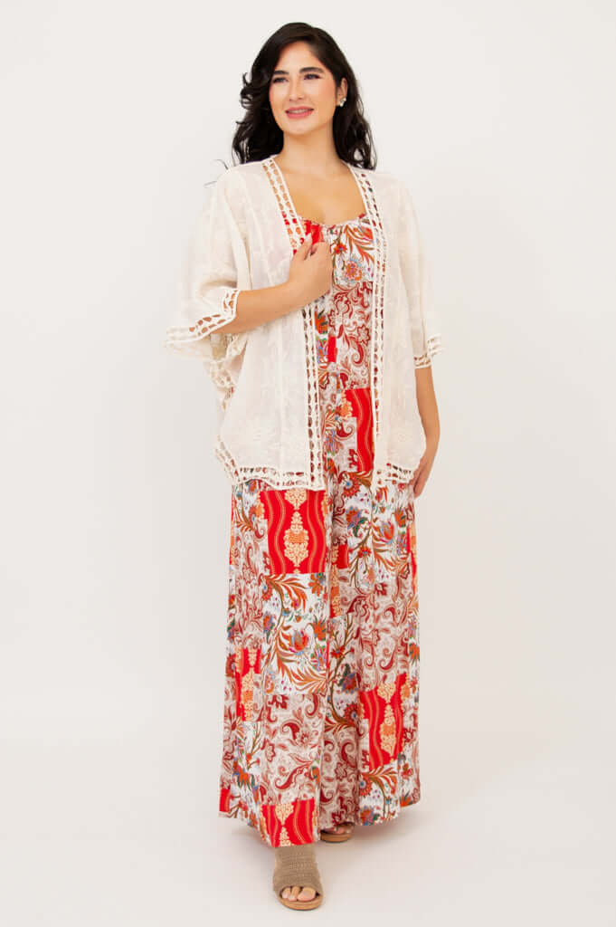 Woman layering a cream lace kimono over a red patchwork jumpsuit