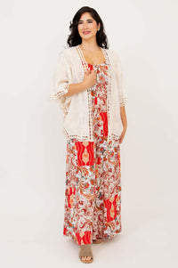Woman layering a cream lace kimono over a red patchwork jumpsuit