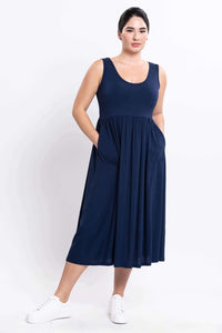 Curvy model wearing indigo sleeveless midi dress with pockets