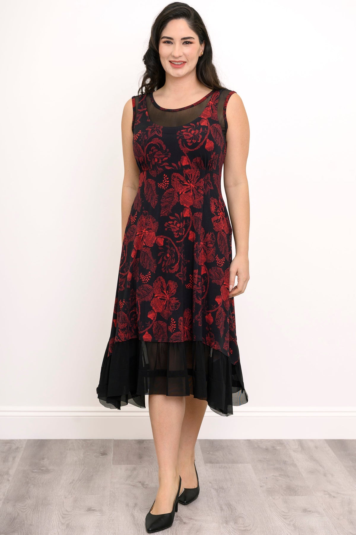 Smiling woman wearing a sleeveless red and black floral print bamboo dress with a round neck, front close-up.