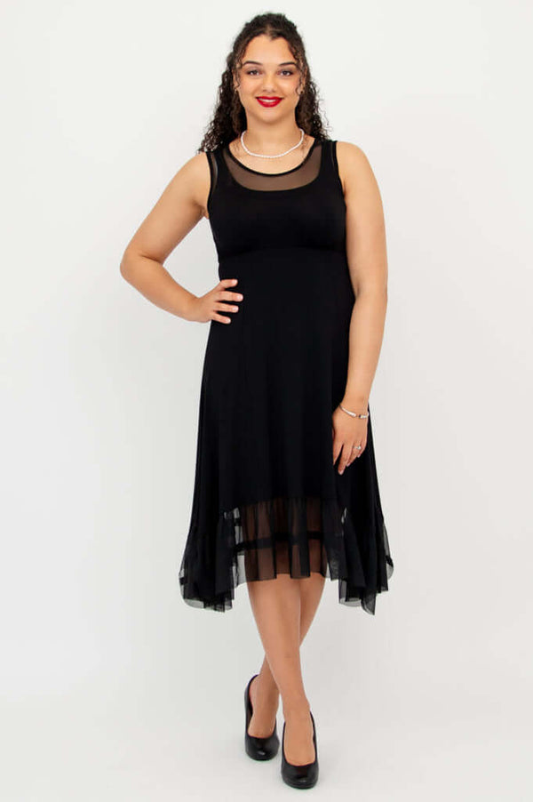 Front view of model wearing black dress with mesh detailing at neckline and hem
